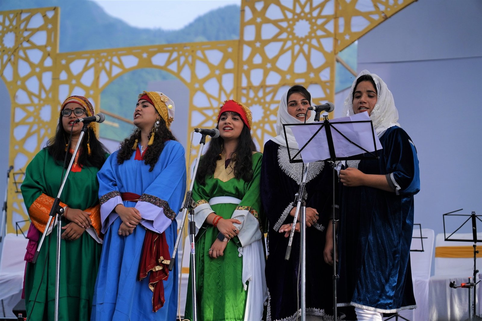 Kashmiri ensemble seated on a patterned stage carpet
