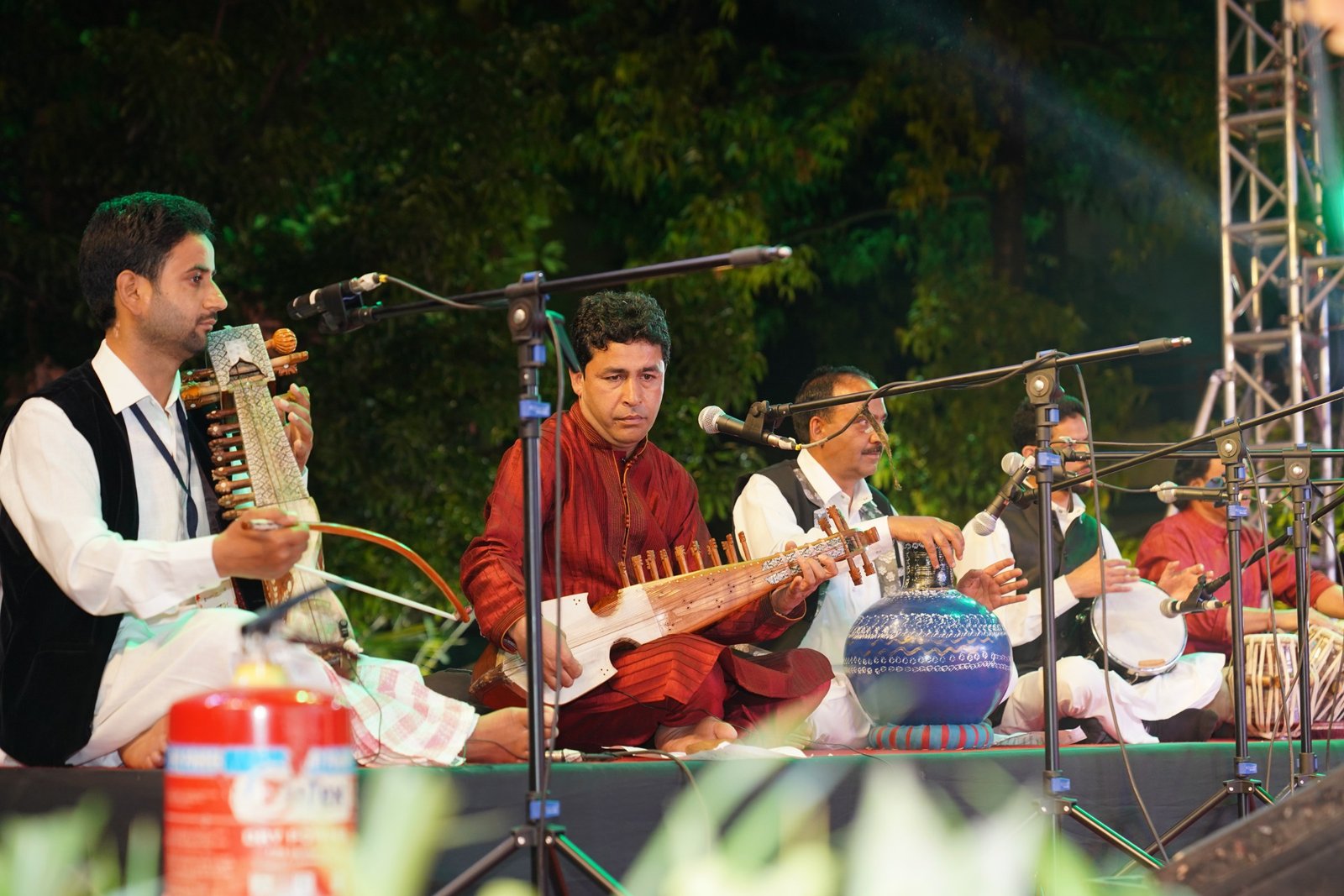 Rabab, sarangi and tabla players on an open-air night stage