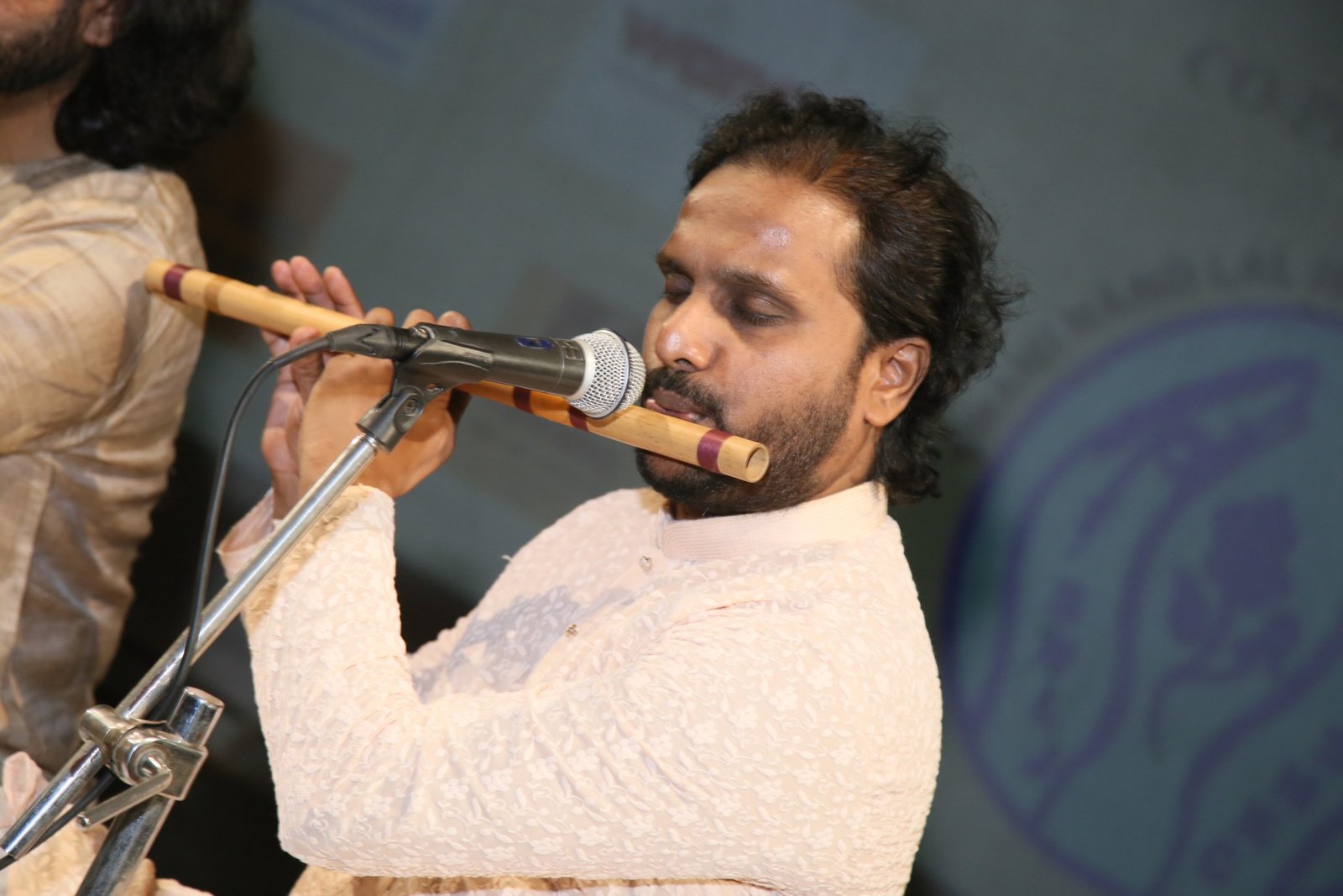 Bansuri player mid-phrase during a classical concert